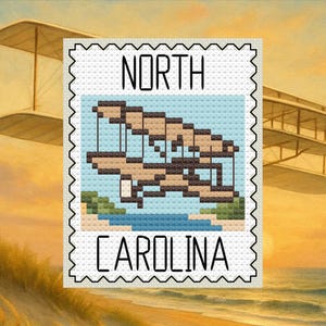 May include: A cross-stitch design of a stamp featuring the text "NORTH CAROLINA" and an image of an airplane over a beach and water. The stamp is framed by a black, scalloped border. The background shows a sunset and a biplane.