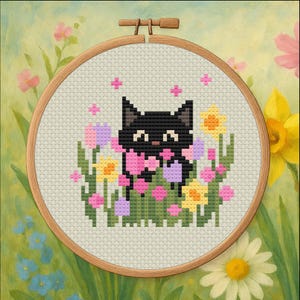May include: A cross-stitch embroidery featuring a black cat amidst colourful flowers, including pink, yellow, and purple blooms. The cat has a pink bow and is set in a wooden embroidery hoop. The background is a soft, painted floral scene.
