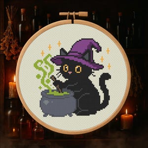 Peut inclure: Broderie au point de croix d'un chat noir portant un chapeau de sorcière violet, remuant un chaudron bouillonnant de potion verte. Le chat a des yeux jaunes et est entouré d'étoiles orange. Le motif est dans un cercle à broder en bois.