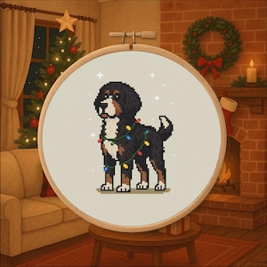 May include: A cross-stitch embroidery hoop featuring a Bernese Mountain Dog decorated with Christmas lights. The dog is black, brown, and white, with a festive holiday theme. The background shows a Christmas tree, fireplace, and wreath.