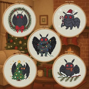 May include: Five cross-stitch hoops featuring a black moth with red eyes. The moth is decorated with a Christmas wreath, Santa hat, Christmas lights, a Christmas tree, and a scarf. The hoops are displayed on a table with a Christmas tree and fireplace in the background.