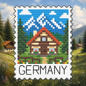May include: A cross-stitch pattern shaped like a postage stamp featuring a brown house with a red roof, green pine trees, and white mountain peaks against a blue sky. The word GERMANY is printed in black capital letters at the bottom edge.