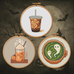 Pode incluir: Três designs de ponto cruz com tema de Halloween em aros de madeira. Um apresenta um café gelado cheio de fantasmas, outro um latte de especiarias de abóbora com fantasmas e o último uma bebida verde assustadora com fantasmas. O fundo inclui morcegos e uma casa assombrada.