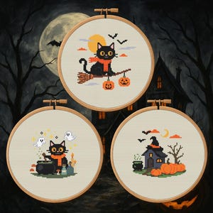 May include: Three framed cross-stitch artworks with Halloween themes. One shows a black cat on a broom, another a cat with a cauldron, and the third a haunted house with pumpkins. The background is a spooky night scene.