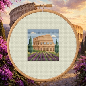 May include: A cross-stitch embroidery featuring the Colosseum in Rome, Italy, set against a scenic background. The design includes lavender fields, trees, and a blue sky with clouds. The embroidery is framed in a wooden hoop.