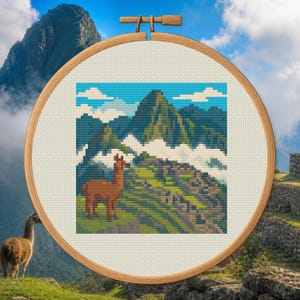 May include: A circular wooden embroidery hoop containing a cross-stitch pattern of a brown llama standing on a grassy hillside with stone ruins and a large mountain peak in the background under a blue sky with white clouds.