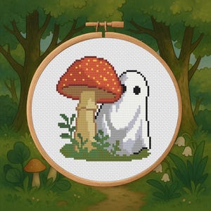 Può includere: Ricamo a punto croce con un fungo rosso e bianco e un fantasma bianco. Il disegno è ambientato in un telaio di legno, con uno sfondo di foresta. Il fungo ha un cappello maculato e il fantasma ha occhi neri.