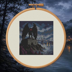 Könnte beinhalten: Ein runder Holzstickrahmen mit einem Kreuzstichmuster, das ein geflügeltes Wesen mit leuchtend roten Augen auf einer felsigen Klippe zeigt. Das pixelige Design stellt eine dunkle Landschaft mit einer Brücke und entfernten Lichtern dar.