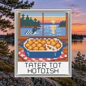 May include: A cross-stitch pattern featuring a blue casserole dish filled with golden tater tots, set against a window view of a lake, trees, and a loon at sunset. The text TATER TOT HOTDISH is printed in black at the bottom of the design.