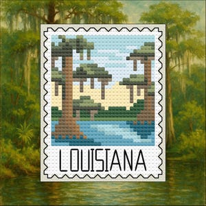 May include: A cross-stitch design of a Louisiana landscape, featuring trees, water, and a blue sky. The word "LOUISIANA" is displayed in bold, black letters at the bottom of the design. The design is framed with a black, postage stamp-like border.