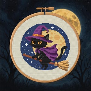 以下が含まれることがあります： 木製のフレームに入ったクロスステッチ刺繍。黒猫が魔女の帽子とマントを身につけ、満月の前をほうきに乗って飛んでいます。背景は星と木のシルエットがある濃い青色の夜空です。