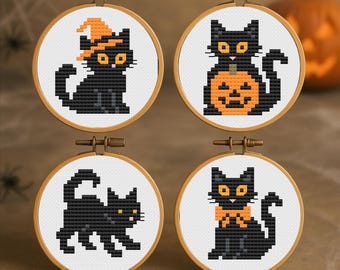 May include: Four small, round embroidery hoops with cross-stitched black cats. Each cat has yellow eyes and is in a different pose, with one wearing a witch's hat and another holding a pumpkin. The hoops are set against a brown background.