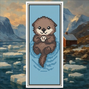 Op de afbeelding: Kruissteekpatroon van een bruine otter die in blauw water drijft. De otter bevindt zich in een ontspannen houding, met gevouwen poten. De achtergrond toont een landschapsschilderij van bergen, water en een klein huisje.