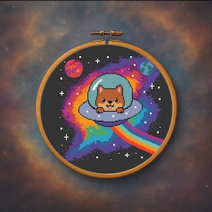 May include: A cross-stitch embroidery in a wooden hoop features a pixelated dog in a spaceship, set against a vibrant, colorful galaxy background. The design includes planets, stars, and a rainbow beam, creating a whimsical space theme.