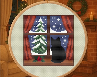 May include: Cross-stitch embroidery in a wooden hoop depicts a black cat gazing out a window at a snowy winter scene. The window shows two green Christmas trees, red curtains, and falling snow. A cozy holiday theme.