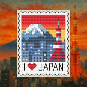 May include: A cross-stitch design of a postage stamp with the text "I ❤️ JAPAN". The stamp features a pixelated image of Mount Fuji, a cityscape, and a red tower. The background shows a cityscape and a sunset.