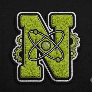 May include: A lime green chenille letter N patch featuring a white and black border. The letter is decorated with a central white atomic symbol and small lime green gear motifs on the sides, all set against a solid black fabric background.