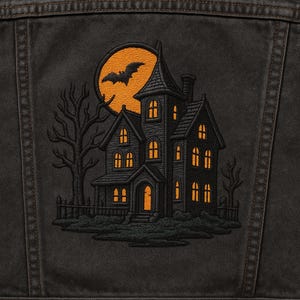 May include: Black denim jacket with a Halloween-themed embroidered patch. The patch features a spooky haunted house with glowing windows, a bat silhouetted against a full orange moon, and bare trees.