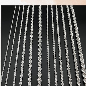 May include: A collection of silver-colored chain necklaces in various styles and thicknesses against a black background. The chains are displayed vertically, showcasing different rope and link designs. Text at the top reads, "For different custom chain options, please feel free to contact us."