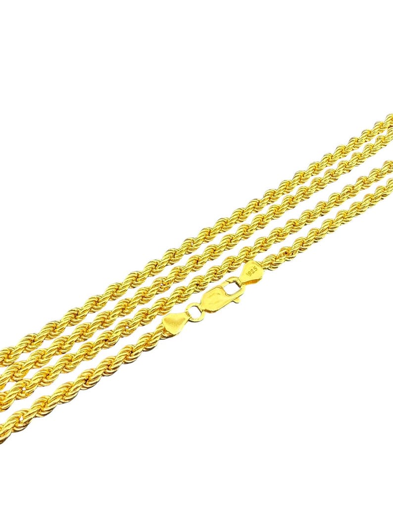 May include: Gold-colored rope chain necklace with a lobster clasp. The necklace is made of multiple strands of twisted metal, creating a rope-like texture. The clasp is marked with "925".
