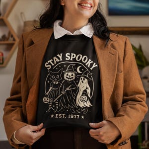 Cozy Stay Spooky Halloween sweatshirt with ghost design, women’s fall crewneck perfect for spooky season outfits and festive Halloween gifts