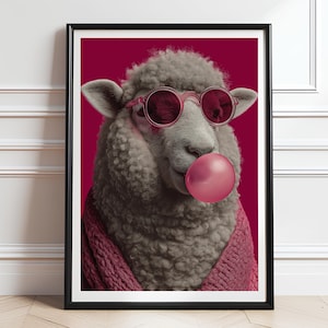 May include: Framed art print of a sheep wearing pink sunglasses and a pink sweater, blowing a pink bubble. The background is a solid magenta colour. The artwork is in a black frame.