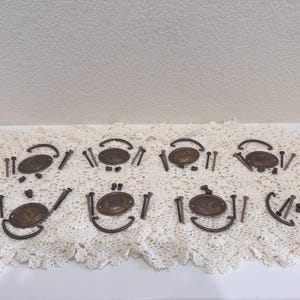 Puede incluir: Un letrero de madera rústico blanco con la palabra "Welcome" escrita a mano. El letrero tiene un aspecto envejecido y un elemento floral decorativo. El fondo es una textura de madera borrosa.