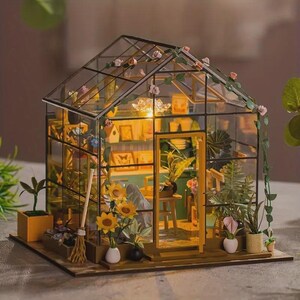May include: A miniature greenhouse model with a glass roof and walls, filled with tiny plants, flowers, and miniature furniture. The structure is adorned with floral vines and small pink flowers. The interior is illuminated, creating a warm, inviting glow. The base is made of wood.