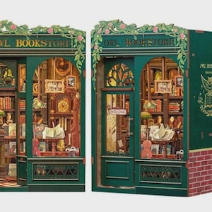 K&ouml;nnte beinhalten: Zwei Miniaturmodelle der Owl Bookstore. Die Fassaden sind dunkelgr&uuml;n mit floralen Akzenten und den Worten "OWL BOOKSTORE" &uuml;ber den T&uuml;ren. Die Innenr&auml;ume sind mit winzigen B&uuml;chern, Uhren und Lampen gef&uuml;llt. Eines hat einen roten Ziegelsockel.