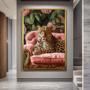 May include: A framed artwork featuring a leopard resting on a pink tufted sofa. The leopard has a spotted coat and is set against a backdrop of pink flowers and green foliage. The frame is gold.