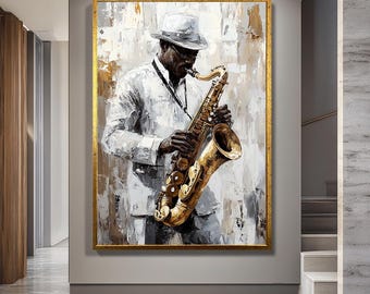 Op de afbeelding: Een ingelijst schilderij toont een zwarte muzikant die een gouden saxofoon bespeelt. De muzikant draagt een wit pak en hoed. De achtergrond heeft abstracte penseelstreken in wit, grijs en goud.