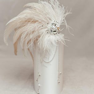 Boho-inspired feather headdress perfect for music festivals, bohemian weddings, or nature-themed photo shoots. Handmade with soft white ostrich feathers and natural rooster feathers, adorned with delicate pearls, crystals, and lace for a dreamy, earthy vibe. This lightweight and expressive headpiece adds artistic flair to any outfit. Displayed on a neutral mannequin head to highlight its flow, texture, and intricate handcrafted details under soft lighting.