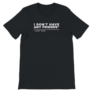 Peut inclure: Un t-shirt noir à manches courtes avec un texte blanc imprimé sur la poitrine qui indique I DON'T HAVE ANY FRIENDS* suivi d'une ligne horizontale et du texte plus petit * except Claude. Le vêtement a un col rond et une coupe standard.