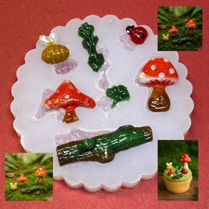 May include: A silicone mold with various miniature fairy garden elements. The mold includes a red mushroom with white spots, a green log, a ladybug, and other small, colorful pieces. The mold is white with a scalloped edge.