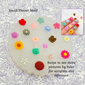 May include: A collection of small, colorful flower-shaped resin embellishments. The flowers are in various colors, including red, pink, yellow, blue, and green. The text "Small Flower Mold" is at the top, and "Swipe to see more pictures by ruler for accurate size reference" is at the bottom.