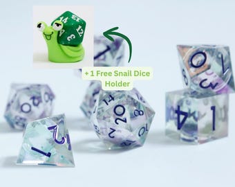 May include: A collection of clear, multi-sided dice with purple numbering, alongside a green snail-shaped dice holder. The dice have a colorful, iridescent interior. The text reads "+ 1 Free Snail Dice Holder".