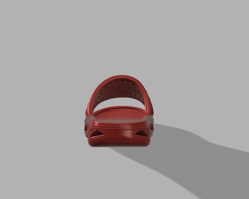 May include: A single red slide sandal, seen from the front. The sandal features a moulded design with a strap across the top and a textured footbed. The colour is a deep, solid red.