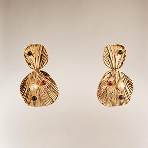 Könnte beinhalten: Ein Paar goldfarbene Ohrringe mit einem strukturierten, organischen Design. Jeder Ohrring hat einen oberen und einen größeren unteren Teil, verziert mit einem grünen, roten, weißen und blauen Edelstein. Die Ohrringe haben einen Steckerverschluss.