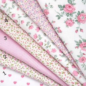 May include: Seven folded fabric swatches from the Pink Ballet Collection, labeled 1 through 7. Patterns include white with pink hearts, pink stripes, and various floral prints featuring pink roses, small blossoms, and green leaves on white backgrounds.