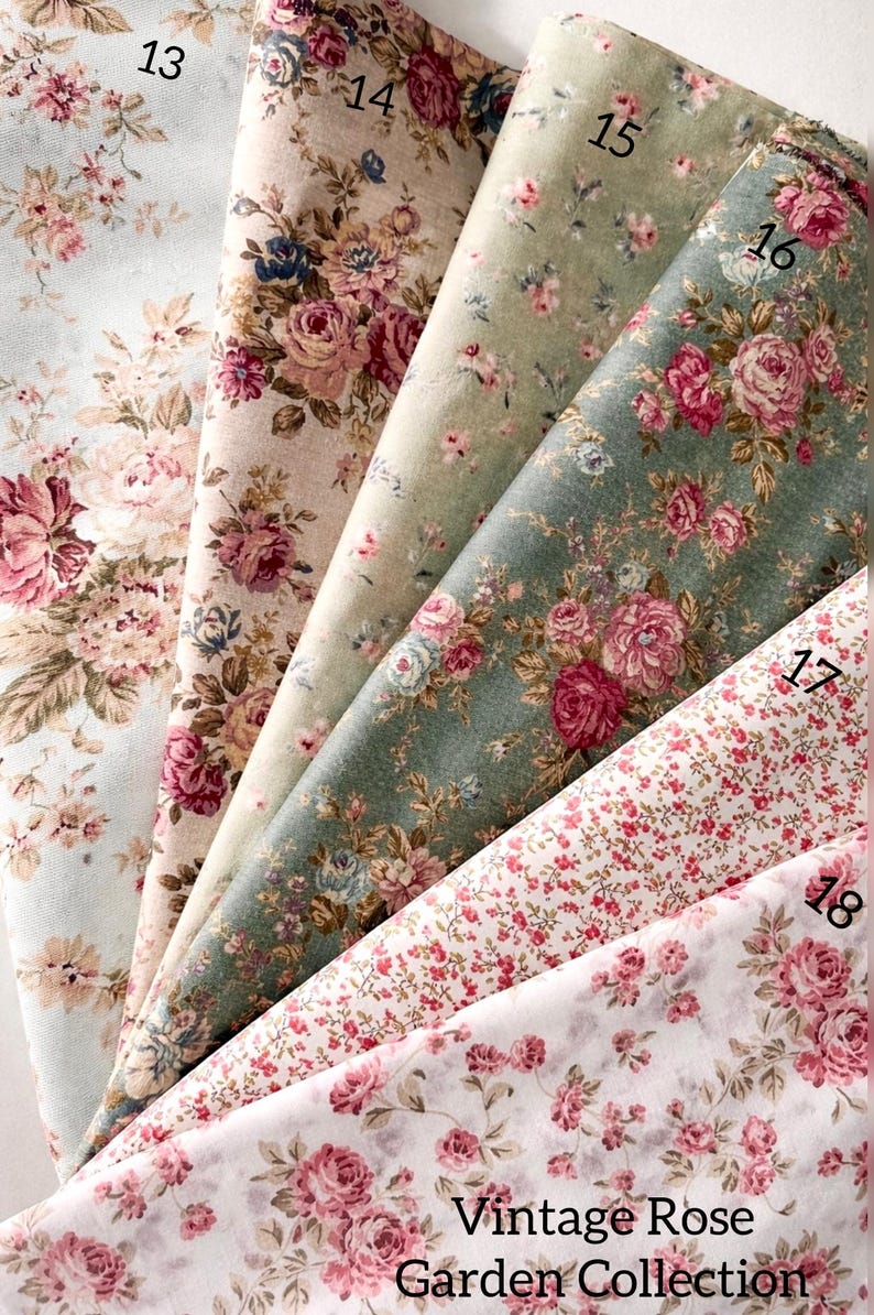 May include: Six folded fabric swatches labeled 13 through 18, featuring floral patterns with pink roses and green foliage on various backgrounds including light blue, beige, sage green, and white. The text reads Vintage Rose Garden Collection.