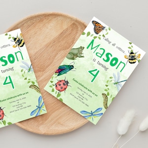 May include: Two light green birthday invitations with insect illustrations. The invitations read "Mason is turning 4" with the text "Come celebrate with us on Sunday Feb 12, 2025". The invitations are on a wooden tray.