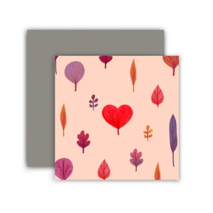 May include: A pink background with a repeating pattern of red, orange, purple, and pink leaves. A red heart-shaped leaf is in the center of the image.