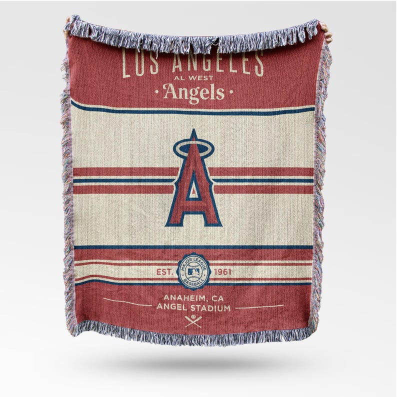 Puede incluir: Una manta tejida roja, blanca y azul con el logotipo del equipo de b&eacute;isbol Los Angeles Angels. La manta tiene un borde con flecos e incluye el nombre del equipo, el logotipo y la informaci&oacute;n del estadio.