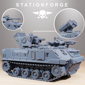 May include: A gray model tank with multiple turrets, cannons, and missile launchers. The tank has a detailed track system and is set against a light gray background. The text "STATIONFORGE" is visible at the top.