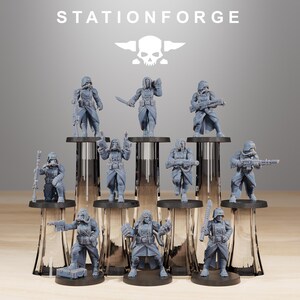 May include: A collection of gray miniature figurines of soldiers, each with unique armor and weaponry. The figurines are arranged on clear glass stands, with the "STATIONFORGE" logo and a skull emblem at the top.