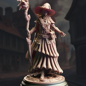 May include: A detailed figurine of a woman wearing a wide-brimmed hat and a long, flowing dress. She holds a staff with a leafy top and has a serious expression on her face.