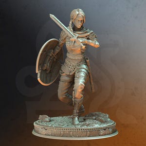 May include: A gray, detailed miniature figurine of a female warrior holding a sword and shield. The figurine is standing on a circular base with a decorative design.