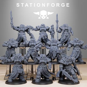 May include: A collection of gray miniature figurines of armored figures, some holding weapons. The figures are arranged on a black display stand. The word "STATIONFORGE" is printed above the figures, along with a skull logo.