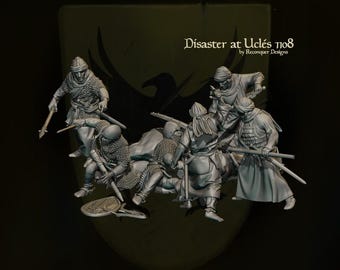 May include: A detailed miniature diorama depicting a battle scene with several figures in historical attire. The figures are engaged in combat, with swords and other weapons. The text "Disaster at Uclés 1108" is visible.