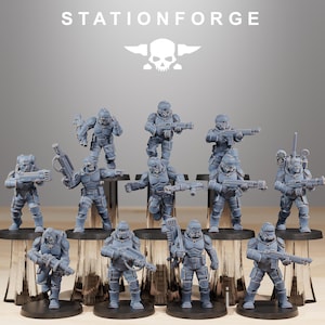 May include: A collection of gray miniature figurines of soldiers in futuristic armor, each holding a weapon. The figurines are arranged on black circular bases and platforms. The word "STATIONFORGE" is displayed above the figurines, along with a skull and wings logo.